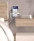 2 Pack Surge Protector Power Strip With 4 USB Ports mounted on wall, charging devices on a bedside table.