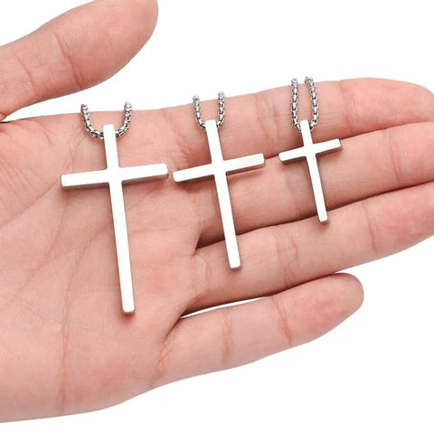 Hand holding Dope Silver Stainless Steel Cross Necklace for Men with 20 Inch Box Chain Pendant, hypoallergenic and lead free.