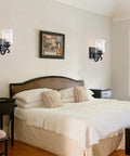Winsmart Black Wall Sconces Set of Two Hard Wired, positioned beside a bed in a cozy bedroom setting.