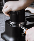 Pro Stainless Steel 58mm Coffee Distributor And Tamper With Slow Rebound Spring in use to compress coffee grounds for espresso.