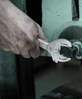 Hand using Joker 6006 Self-Setting Double Spanner With Auto-Grip For Metric And Imperial Fasteners on machinery bolt