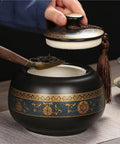 Airtight Ceramic Tea Canister With Silicone Seal Lid For Loose Leaf Coffee Beans Snacks And Nuts Keeps Kitchen Stash Crisp Locks In Flavor, black and gold ornate design, hand opening lid with tea scoop.