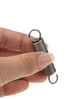 Close-up of two small stainless steel extension springs with dual hooks, 0.4x2 in, held between fingers