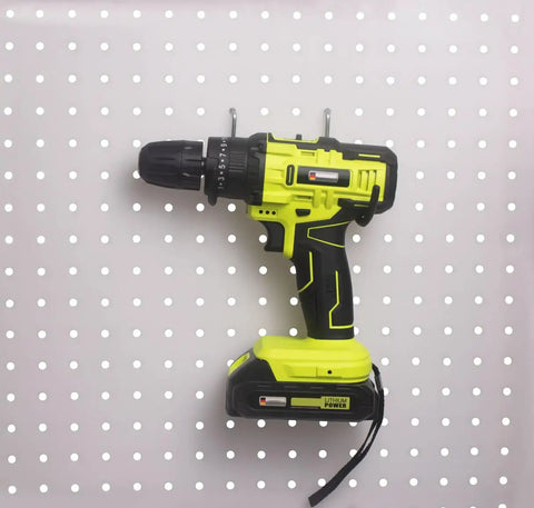 Six Pack Heavy Duty Pegboard Drill Holder Set With Rubber Coated Tool Hooks For Drills And Power Tools Keeps Garage Or Shed Neat And Within Easy Reach installed on pegboard with drill.