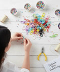 Person crafting with colorful 36 Pcs Colorful Swivel Snap Hooks Lobster Claw Clasps For Diy Crafts Jewelry Making on a workspace.