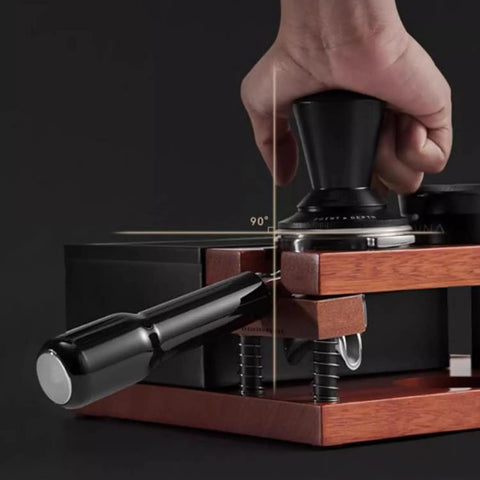 Top Shelf Solid Walnut Espresso Knockbox Station With Five Dedicated Slots For 51 54 And 58 Millimeter Portafilters, showing tamper usage.