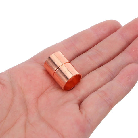 Premium Copper Coupling Fittings 0.59 Inch Straight Pipe Connectors shown in hand, ideal for HVAC and plumbing applications.