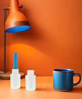 Four Rolls Stretch Film Wrap With Ergonomic Handles for moving on an orange table beside a blue mug and orange lamp
