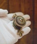 Gloved hand holding a vintage style round drawer knob for dresser cabinet cupboard wardrobe pull handles with screws pack of 6 golden antique brass retro look ready for easy DIY cabinet makeover.