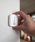 Person installing Wireless Motion Alert Sensor 2 Pack For Indoor And Outdoor Use Weatherproof And Easy Install No Hub Required.