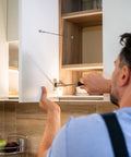 Man installing Premium Tough As Nails Stainless Steel Cabinet Door Stops And Hinge Limiters with adjustable size for kitchen cabinets.
