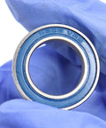 15x24x5mm Chrome Steel Cartridge Bearings With Grease Seal Blue Beefed-Up Full Ball 6802LLU For Hubs And Pivots Pack Of 4 Sealed Bearings High Load Capacity Rugged Durability. Blue sealed 6802LLU bearing held in gloved hand
