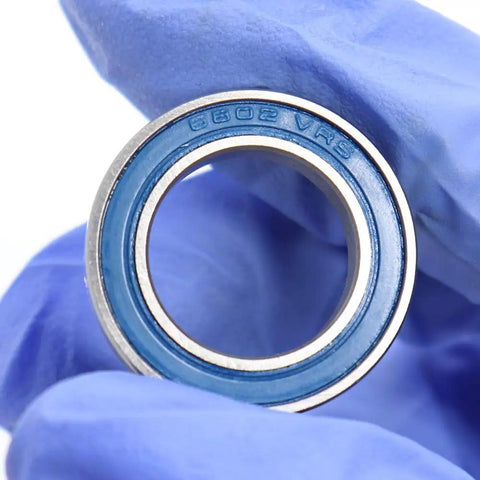 15x24x5mm Chrome Steel Cartridge Bearings With Grease Seal Blue Beefed-Up Full Ball 6802LLU For Hubs And Pivots Pack Of 4 Sealed Bearings High Load Capacity Rugged Durability. Blue sealed 6802LLU bearing held in gloved hand