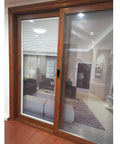 Wooden framed sliding glass door with view of modern living room interior with furniture and decor.