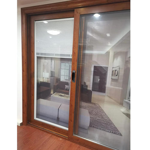 Wooden framed sliding glass door with view of modern living room interior with furniture and decor.