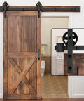 Heavy Duty Boss Grade Black Barn Door Hardware Kit For Wood Sliding Doors Five To Sixteen Feet Flat Track System With Big Spoke Wheel Rollers Carbon Steel Build Dual 3.75 Foot Tracks Ideal For Closet Or Garage Use installed on wooden door
