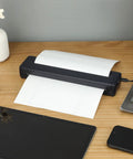 Slick Wireless Tattoo Transfer Stencil Printer For A4 Paper Offering Hassle Free Inkless Thermal Output on a desk with paper.