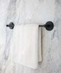 No Drill Strong Suction Cup Towel Bar on marble wall with towel, matte black finish, adjustable 20.5 to 32.2 inch wall mounted