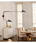 Slick Adjustable Double Head Wall Sconce Lamp In Modern Black Finish With Swivel Pole Design For Cozy Bedroom Reading Vibes And Chic Home Decor Upgrades located beside dining table.