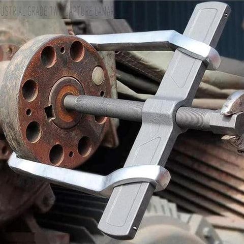 MANNIFEN 2-jaw gear puller gripping a rusted automotive pulley hub; gray steel tool with threaded center rod