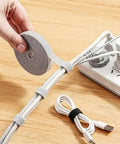 Person using Adjustable Reusable 5M Hook and Loop Cable Ties for Quick Cord Management, Self Gripping Wire Organizer in gray.
