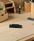 Hidden 5 Inch Black Concealed Wood Door Hinges for Secret Doors and Bookcases, placed on a wooden desk, showcasing sleek design.