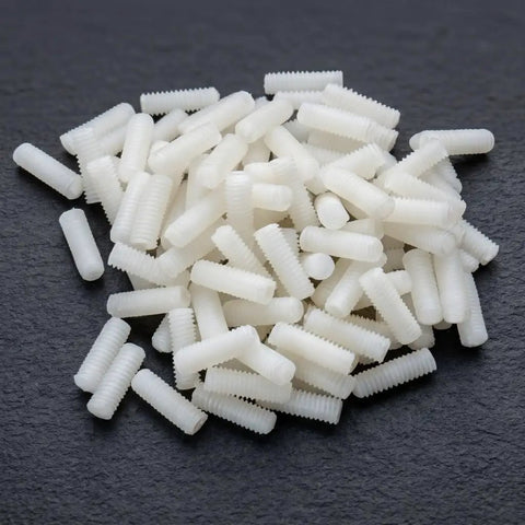 Top Shelf M4 X 12mm Nylon Slotted Set Screws, white plastic grub fasteners scattered on dark surface