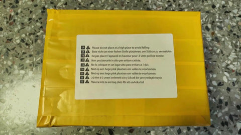 Yellow packaging with multilingual warning label stating "Please do not place at a high place to avoid falling."