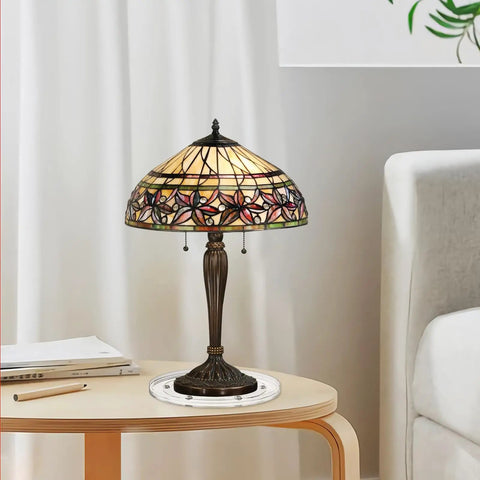 Tiffany-style stained glass table lamp on wooden side table next to a white sofa in a living room setting.