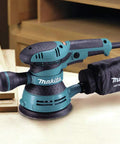 5 Inch Random Orbit Sander With 3 Amp Motor And Variable Speed Dial 4,000 To 12,000 OPM on workshop table