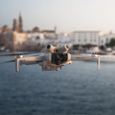 Mini 4 Pro Folding Drone With RC 2 Remote And Screen Fly More Combo 4K HDR Video Camera flying over a scenic water view