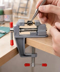 Zero Drama Mini Bench Vise Sturdy Table Mount Badass High Carbon Steel Adjustable Clamp For DIY Models Jewelry Woodworking And Precision Hobbies With Grips That Lock Down Fast in use, holding a model piece with precision.
