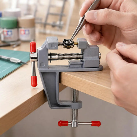 Zero Drama Mini Bench Vise Sturdy Table Mount Badass High Carbon Steel Adjustable Clamp For DIY Models Jewelry Woodworking And Precision Hobbies With Grips That Lock Down Fast in use, holding a model piece with precision.