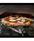 9 Inch Round Perforated Aluminum Pizza Peel With Detachable 40 Inch Handle Lightweight Yet Durable Pizza Turner For High Heat Ovens Outdoor Pizza Oven Accessories For Easy Slide And Turn Pro Grade - pizza being turned