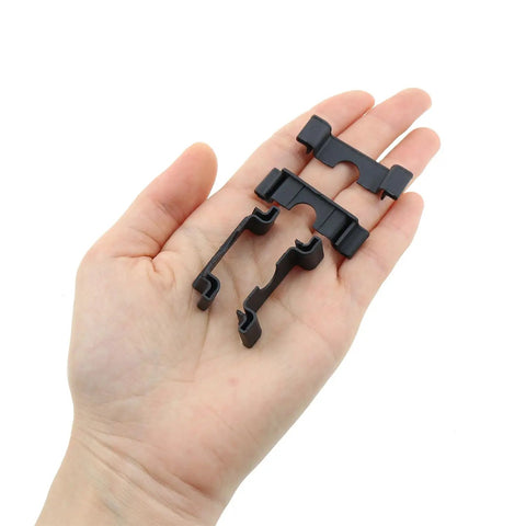 Hand holding Durable 35mm DIN Rail End Cap Protector Covers For Terminal Blocks, Black Plastic End Mount, Clamp Style, 30 pack.