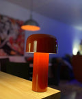 Cordless USB Rechargeable Desk Lamp With Touch Dimming in red on tabletop with living room background