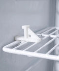 Close-up of No Mess Freezer Shelf Clips 10 Pack for Fridge Organization on frosted wire rack, heavy duty plastic white support.