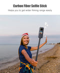 Carbon Fiber Selfie Stick With Telescopic Shaft Reaches Near Fifty Nine Inches for wider filming on beach with smiling woman.