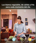 Woman cooking under Hue LightStrip Plus Dimmable LED Smart Light Extension for Ambient Mood Lighting, warm and cool tones