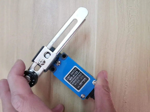 Hands holding Two Pack ME 8108 Momentary Limit Switch with Rotary Adjustable Roller Lever Arm, ideal for CNC mills and Arduino projects.