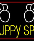 Image of Puppy Spa neon sign with paw prints on black background.