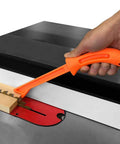 Bright Orange Safety Push Stick Set For Table Saw And Band Saw Ergonomic Handles shown guiding wood on table saw