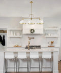 Three Light Linear Chandelier In Matte White With Brass Accents above kitchen island, adjustable hanging, glam luxe vibe.