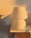 Mushroom Glass Desk Lamp With White Stripes, Vintage Murano Hand-Blown Style, on a shelf, warm light illuminating the background.