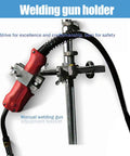 Welding gun holder with manual adjustment bracket and rubberized grip for secure operation on metal work surfaces.