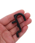 150 Pcs Plastic Pegboard Hooks For Tool Storage With Stable Holding Structure And Flexible Storage Layout Black Self Locking Peg Hooks For Kitchen And Workshop Organization Super Handy For Quick Access black plastic pegboard hook held in hand