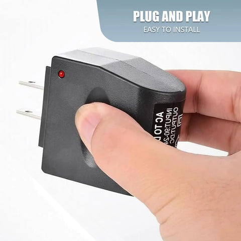 Zero Hassle Wall To Ride Power Adapter Runs Your Car Gadgets Indoors, hand holding black AC to DC adapter with plug.