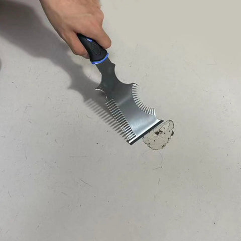 The Smooth Operator All In One Paint Brush And Roller Cleaning Tool with heavy duty steel blade scraping paint off a surface.