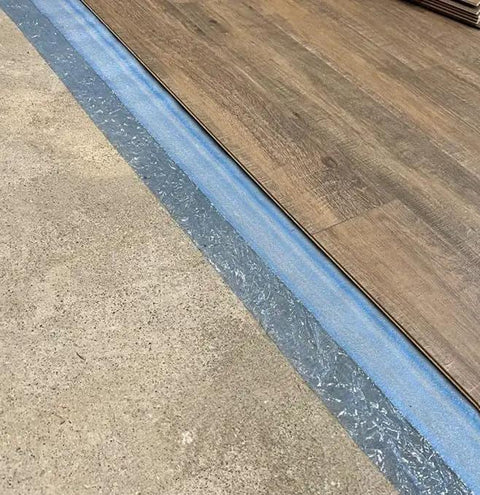 Game Changing 3in1 Vapor Barrier Flooring Underlayment With Pre Attached Tape For Laminate And Engineered Floors On Wood Or Cement Sub Floors Covers 100 Square Feet Quick Lay Down Smooth And Solid Finish, showing installation over concrete.