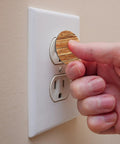 Hand installing Slick Pine Wood Texture Child Proof Outlet Covers For Wall Sockets on a white wall socket.